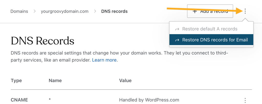 Pantalla Registros DNS y una flecha que señala al menú de tres puntos con la opción de restaurar los registros DNS para el correo electrónico.